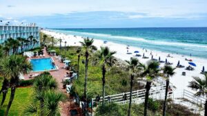 View looking down over Casa Loma and their pool and beach area on a sunny day with a bright blue ocean in Panama City, Florida, USA
